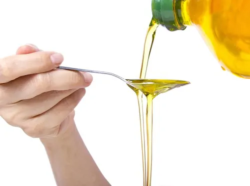 vegetable oil pouring on spoon