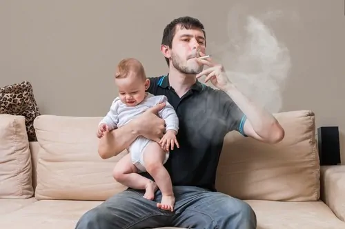 man smoking holding baby