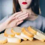 celiac disease woman gesturing refusal of offered bread